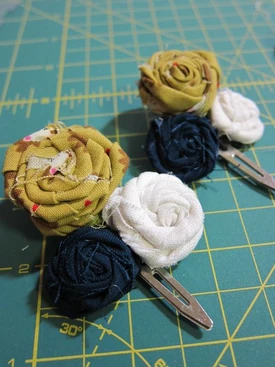 http://www.thezenofmaking.com/2011/06/fabric-rosette-barrette-tutorial
