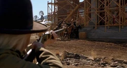 Doc aims his rifle towards the rope.