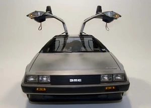 A De Lorean DMC-12 from the front with the gull-wing doors open.