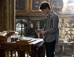 Harry Potter (holding the Elder Wand) and Minerva McGonagall mourn the death of Albus Dumbledore.