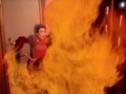 Ein Mann in Flammen rennt auf Major Kira zu
