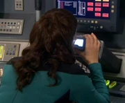 In 2370, Commander Deanna Troi examines the holographic recreation of a scope from 2161