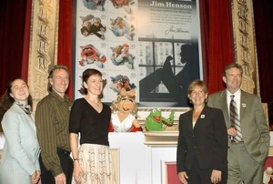Heather Henson, Brian Henson, Lisa Henson, Miss Piggy, and Kermit the Frog stand before the new Muppet stamps at the first day of issue ceremony held at The Television Academy in North Hollywood.