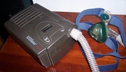 A typical CPAP machine houses the air pump in a case lined with sound-absorbing material for quieter operation.  A hose carries the pressurized air to a face mask that encloses the oral and nasal airways.