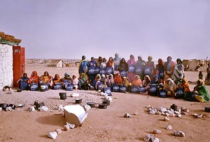 Darfur refugee women pose with their donated CooKit solar panel cookers.
