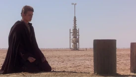 Anakin Skywalker kneels and pays respect to his mother's grave.