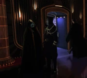 Eekway converses with Baron Papanoida outside Chancellor Palpatine's private box at the Galaxies Opera House.