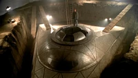 A cult leader known as Josepho stands atop an unearthed UFO.